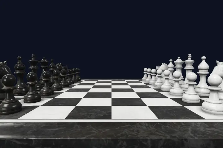 Close-up of marble chess pieces with soft studio reflections on a polished board